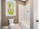 Bathroom featuring a toilet, tub, and a window letting in natural light at 100 Regina Ct, Fayetteville, GA 30215