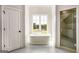 Bright bathroom featuring a soaking tub beneath a window and a glass-enclosed shower with tile surround at 100 Regina Ct, Fayetteville, GA 30215