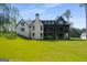 Rear exterior of the home with a screened porch, brick facade, and a large, well-maintained lawn at 100 Regina Ct, Fayetteville, GA 30215