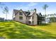 Spacious lawn and brick facade, with a view of the home's screened porch and multi-car garage at 100 Regina Ct, Fayetteville, GA 30215