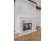 Close up of the fireplace, with white mantle and gas logs. Hardwood floors visible at 100 Regina Ct, Fayetteville, GA 30215