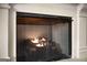 Close up view of fireplace with fire burning and decorative metal screen at 100 Regina Ct, Fayetteville, GA 30215