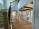 View of the foyer, staircase, and open floor plan with hardwood floors and beam ceilings at 100 Regina Ct, Fayetteville, GA 30215