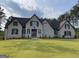 Charming two-story home with a landscaped yard and classic brick facade under a cloudy sky at 100 Regina Ct, Fayetteville, GA 30215