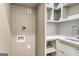 Functional laundry room featuring a sink, ample countertop space, and open shelving for storage at 100 Regina Ct, Fayetteville, GA 30215