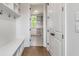 Well-organized mudroom with built-in bench, shelves, and storage, leading to a bright utility room at 100 Regina Ct, Fayetteville, GA 30215