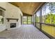 A covered patio with a brick fireplace, wood ceiling, and views of the surrounding trees and foliage at 100 Regina Ct, Fayetteville, GA 30215