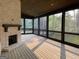 Inviting screened porch with a fireplace, offering serene views of the surrounding greenery at 100 Regina Ct, Fayetteville, GA 30215