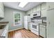 Cozy kitchen featuring painted cabinets, laminate counters, stainless sink, and white appliances at 810 Bedford Park, Peachtree City, GA 30269