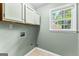 Well-lit laundry room with ample cabinet space and a window with a view at 810 Bedford Park, Peachtree City, GA 30269