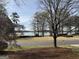 Scenic view from the property overlooking a tranquil lake, framed by trees and a well-manicured lawn at 107 Terrane Rdg, Peachtree City, GA 30269