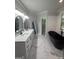 Elegant bathroom featuring a freestanding black tub, double vanity with marble countertop, and modern fixtures at 107 Terrane Rdg, Peachtree City, GA 30269