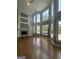 Bright living room showcasing hardwood floors, large windows, and built-in shelving around a cozy fireplace at 107 Terrane Rdg, Peachtree City, GA 30269