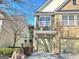 View of the exterior brick and siding of townhome at 2540, featuring a one-car garage and manicured front garden at 2540 Willow Grove Road Nw Rd # 15, Acworth, GA 30101