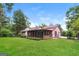 Well-maintained backyard with lush lawn, mature trees, and a screened-in porch at 2624 Windridge Dr, Acworth, GA 30102