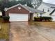 Charming one-story home with brick accents, a two-car garage, and manicured landscaping at 165 Lakeside Pt, Covington, GA 30016