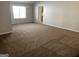 Bright living room with a large window and neutral carpeting at 165 Lakeside Pt, Covington, GA 30016