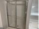 Bathroom shower with sliding doors and white walls, offering a clean and functional space at 165 Lakeside Pt, Covington, GA 30016