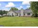 Large backyard with a well-maintained lawn, back patio, and mature trees at 301 Bradford Ct, Auburn, GA 30011