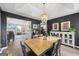 Elegant dining room features modern light fixture, dark accent walls, and view into the open-concept living space at 301 Bradford Ct, Auburn, GA 30011