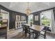 Stylish dining room with wood table, chandelier, dark walls, and view to sunlit backyard at 301 Bradford Ct, Auburn, GA 30011