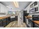 Well-lit kitchen with black appliances, wood countertops, island, and white subway tile backsplash at 301 Bradford Ct, Auburn, GA 30011