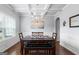Elegant dining room featuring coffered ceilings, hardwood floors, a modern chandelier, and stylish decor at 8 Saint Charles Ave, Sharpsburg, GA 30277