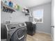 Well-lit laundry room featuring a modern washer and dryer set with ample storage and shelving at 8 Saint Charles Ave, Sharpsburg, GA 30277