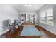 Cozy living room featuring hardwood floors, a blue rug, a window with blinds, and comfortable seating at 8 Saint Charles Ave, Sharpsburg, GA 30277