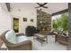 Inviting covered patio features a stone fireplace and comfortable seating for outdoor relaxation and entertaining at 8 Saint Charles Ave, Sharpsburg, GA 30277