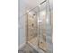 Glass enclosed shower with bench seating, stone tiling and rainfall shower head at 8 Saint Charles Ave, Sharpsburg, GA 30277
