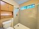A full bathroom features grey tiled shower, cabinets, and a window with natural light at 8846 Wesley Pl, Jonesboro, GA 30238