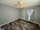 A room with gray walls and dark floors with a ceiling fan and window at 8846 Wesley Pl, Jonesboro, GA 30238