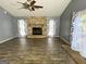 Spacious living room featuring a brick fireplace and large windows offering ample natural light at 8846 Wesley Pl, Jonesboro, GA 30238