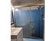 Outdated bathroom with a shower featuring sliding glass doors, a sink, and blue wall paint at 953 South Ave, Forest Park, GA 30297
