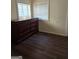 Bedroom featuring dark wood floors and a dresser, illuminated by natural light from two windows at 953 South Ave, Forest Park, GA 30297