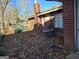 Home exterior showcasing a brick chimney, AC unit, and a yard covered in autumn leaves at 953 South Ave, Forest Park, GA 30297