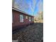 Red brick exterior detail with windows and a yard covered in fallen leaves at 953 South Ave, Forest Park, GA 30297