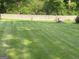 Large backyard featuring manicured grass and a block wall at the back of the property at 6884 Shangrila Way, Riverdale, GA 30296