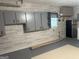 Basement area with cabinets, refrigerator, and epoxy floors, offering versatility and functionality at 6884 Shangrila Way, Riverdale, GA 30296