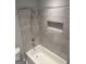 Bathroom features white tub, grey tile surround, and shower niche at 6884 Shangrila Way, Riverdale, GA 30296