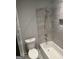 Bathroom with white toilet and bathtub featuring grey tile backsplash and shower at 6884 Shangrila Way, Riverdale, GA 30296