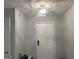 Entryway with light grey paint, white front door, and textured ceiling at 6884 Shangrila Way, Riverdale, GA 30296