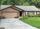 Ranch home with brown siding, stone accents, attached garage, and landscaped front yard at 6884 Shangrila Way, Riverdale, GA 30296