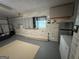 Well-lit garage with gray cabinets, refrigerator, and clean epoxy floor at 6884 Shangrila Way, Riverdale, GA 30296