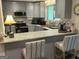 Open kitchen with breakfast bar, granite counters, stainless appliances, and gray striped bar stools at 6884 Shangrila Way, Riverdale, GA 30296