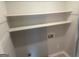 Functional laundry room with shelving above for organizing supplies and equipment, providing convenience at 6884 Shangrila Way, Riverdale, GA 30296