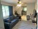 Cozy living room featuring a comfortable blue sofa, rug, and view into the kitchen at 6884 Shangrila Way, Riverdale, GA 30296