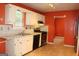 Traditional kitchen featuring bright white cabinets and appliances contrasted by vivid orange walls at 3255 Hunters Crossing Pt, Lithonia, GA 30038