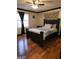 Bedroom featuring dark wood floors, matching furniture, and a window with natural light, creating a warm inviting space at 6340 Koweta Rd, Fairburn, GA 30213